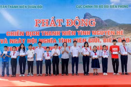 Các đại biểu tặng quà cho các cháu học sinh có hoàn cảnh khó khăn vượt khó, học giỏi. (Ảnh: Huỳnh Sơn/TTXVN)