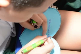 Học sinh trường Mầm non- Tiểu học và Trung học Cơ sở Đức Trí (thành phố Đà Nẵng) viết những bức thư gửi gắm tình cảm, động viên đến học sinh các tỉnh phía Bắc bị ảnh hưởng bởi thiên tai. (Ảnh: Văn Dũng/TTXVN)