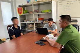 Đối tượng Phan Văn Hiếu (áo đen) tại cơ quan Công an. (Ảnh: TTXVN phát)