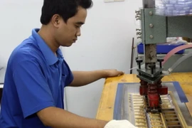 Dập vỏ bao bì vàng miếng SJC mới. (Ảnh: Hoàng Hải/TTXVN)