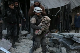 Nhân viên dân sự Syria chuyển một em nhỏ bị thương trong các cuộc giao tranh giữa quân đội chính phủ và phiến quân tại thành phố Aleppo, miền Nam Syria ngày 16/1. (Nguồn: AFP/TTXVN)