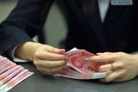 Kiểm đồng nhân dân tệ tại một chi nhánh ngân hàng ở thủ đô Bắc Kinh. (Nguồn: THX/TTXVN)