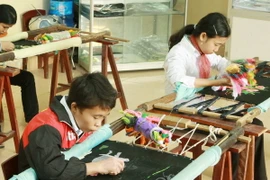 Giờ học nghề thêu của các em bị thiểu năng vận động do di chứng chất độc da cam/dioxin. (Ảnh: Dương Ngọc/TTXVN)