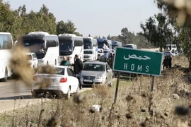 Đoàn xe chở cư dân và phiến quân Syria rời khỏi Waer ở tỉnh Homs ngày 9/12/2015. (Nguồn: AFP/TTXVN)