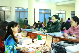 Khách hàng giao dịch tại bộ phận kế toán kiểm soát chi của Kho bạc Nhà nước Hà Nội. (Ảnh: Hoàng Hùng/TTXVN)