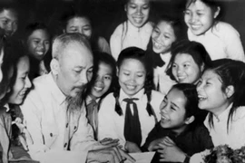 Đoàn đại biểu thiếu nhi học sinh trường nữ Trưng Vương (Hà Nội) quây quần quanh Bác (Ảnh tư liệu TTXVN). 