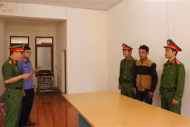 Cơ quan Cảnh sát điều tra Công an tỉnh Lai Châu đọc quyết định khởi tố bị can Đỗ Đình Chiến. (Ảnh: Việt Hoàng/TTXVN)