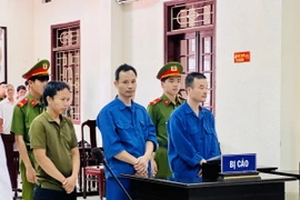 Cựu điều tra viên Đinh Viết Chung (giữa) nghe tòa tuyên án. (Ảnh: Nguyên Linh/TTXVN)