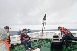 Chiến sỹ tàu Hải quân 468 làm dây để lai kéo tàu của ngư dân Phú Yên. (Ảnh: TTXVN phát)