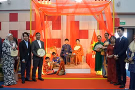 Thứ trưởng Bộ Văn hóa và một số bạn bè Brunei thăm, chụp ảnh cùng người mẫu áo dài Việt Nam tại Triển lãm. (Ảnh: Báo Quốc tế)