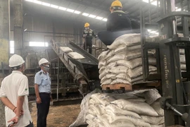 Cơ quan chức năng tiến hành phân hủy lô phân bón gây hại. (Ảnh: TTXVN phát)