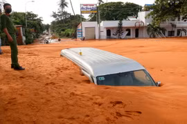 Cát tràn vùi lấp gần như hoàn toàn một xe ôtô 16 chỗ trên tuyến đường Huỳnh Thúc Kháng. (Ảnh: Nguyễn Thanh/TTXVN)