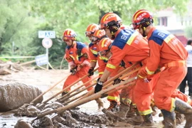 Lực lượng cứu hộ dọn bùn trên đường phố ở thành phố Bảo Kê, tỉnh Thiểm Tây, Trung Quốc sau mưa lớn, ngày 19/7/2024. (Ảnh: THX/TTXVN)