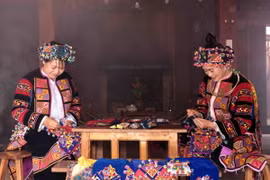 Phụ nữ Lô Lô với bàn tay khéo léo thêu hoa văn trên trang phục truyền thống. (Ảnh: Trần Việt/TTXVN)