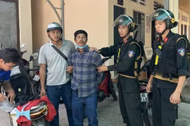 Đối tượng Trương Văn Út (áo sọc đen) bị tạm giữ vì liên quan đến vụ án giết người. (Ảnh: TTXVN phát)