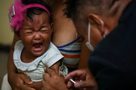 Nhân viên y tế tiêm vaccine ngừa bệnh sởi cho trẻ em tại Caracas, Venezuela. (Ảnh: AFP/TTXVN)