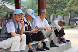 Người cao tuổi nghỉ ngơi dưới bóng râm của một gian hàng ở Công viên Tapgol ở trung tâm thành phố Seoul. (Ảnh: Nikkei Asia)