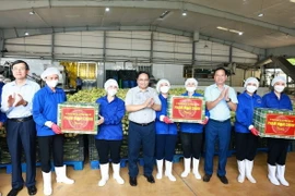 Thủ tướng Phạm Minh Chính tặng quà cho công nhân Công ty cổ phần thực phẩm xuất khẩu Đồng Giao. (Ảnh: Dương Giang/TTXVN)