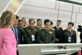 Bộ trưởng Bộ Quốc phòng, Đại tướng Phan Văn Giang và các thành viên trong đoàn tham quan các gian hàng tại ARMY-2024, ngày 12/8/2024. (Ảnh: Quang Vinh/TTXVN)
