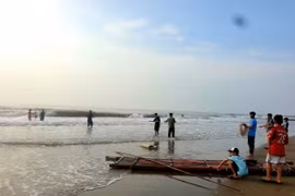 Người dân và gia đình mòn mỏi ngóng trông tin tức của các em. (Ảnh: Hoàng Ngà/TTXVN)