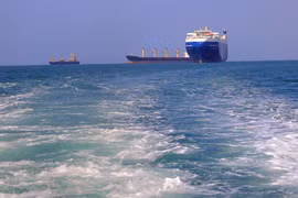 Tàu chở hàng (phải), bị lực lượng Houthi bắt giữ, trên đường về cảng tỉnh Hodeida (Yemen), ngoài khơi Biển Đỏ, ngày 22/11/2023. (Ảnh: AFP/TTXVN)