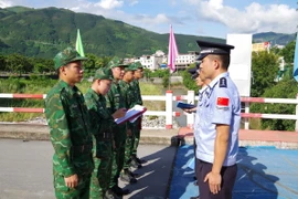 Chỉ huy trưởng tuần tra liên hợp hai bên thông báo, trao đổi thông tin tại vạch phân định cầu hữu nghị cửa khẩu Ma Lù Thàng, Việt Nam và Kim Thủy Hà, Trung Quốc. (Ảnh: TTXVN phát)