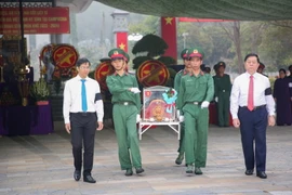 Trưởng Ban Tuyên giáo Trung ương Nguyễn Trọng Nghĩa (phải) và Bí thư Tỉnh ủy, Chủ tịch HĐND tỉnh Tây Ninh Nguyễn Thành Tâm (trái) di an hài cốt liệt sỹ đến nơi an táng. (Ảnh: Giang Phương/TTXVN)