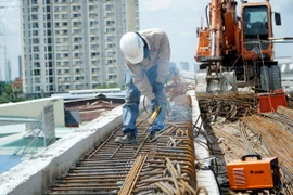 Công nhân thi công trên công trường dự án xây dựng cầu Nam Lý. (Ảnh: Tiến Lực/TTXVN)