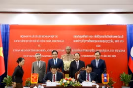 Ông Đinh Văn Thiệu, Phó Chủ tịch UBND tỉnh Khánh Hòa và ông Sililat Thongsin Thongphenh, Phó Đô trưởng Thủ đô Vientiane ký kết Bản ghi nhớ hợp tác giữa hai địa phương. (Ảnh: Phạm Kiên/TTXVN)