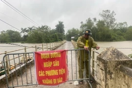 Lực lượng chức năng lập rào chắn và biển cảnh báo người dân không di chuyển qua khu vực nguy hiểm tại thôn Liệp Mai, xã Ngọc Liệp, huyện Quốc Oai. (Ảnh: Vũ Sinh/TTXVN)