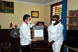 Đại sứ Việt Nam tại Cuba Lê Thanh Tùng trao quà tượng trưng cho Hiệu trưởng trường tiểu học “Bác Hồ” Milagros Negret Calderín. (Ảnh: Vũ Lê Hà/TTXVN)