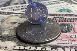Đồng xu ruble của Nga (phía trên) và đồng USD tại Moskva. (Ảnh: AFP/TTXVN)