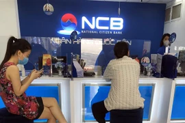 Khách hàng giao dịch tại Ngân hàng TMCP Quốc Dân. (Ảnh: Trần Việt/TTXVN)