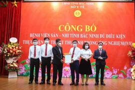 Đại diện Bộ Y tế trao chứng nhận Bệnh viện Sản – Nhi Bắc Ninh đủ điều kiện thực hiện kỹ thuật thụ tinh trong ống nghiệm. (Ảnh: Thanh Thương/TTXVN)