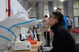 Nhân viên y tế lấy mẫu xét nghiệm COVID-19 cho người dân tại tỉnh Hồ Nam, Trung Quốc, ngày 22/3. (Ảnh: THX/ TTXVN)