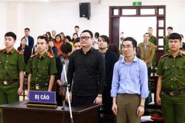 Bị cáo Trần Hữu Tiệp (áo đen) và các bị cáo khác trong vụ án thao túng giá chứng khoán. (Ảnh: Doãn Tấn/TTXVN)