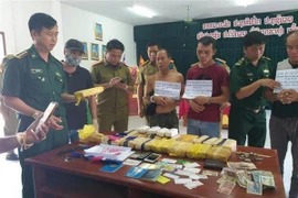 Các đối tượng và tang vật bị bắt giữ tại cơ quan điều tra. (Ảnh: Thanh Thủy/TTXVN)