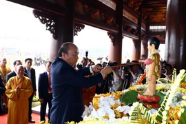 Thủ tướng Chính phủ Nguyễn Xuân Phúc thực hiện nghi lễ tắm Phật. (Ảnh: Thống Nhất/TTXVN)