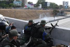 Các tay súng thuộc nhóm binh sỹ ủng hộ thủ lĩnh đối lập Venezuela Juan Guaido được trang bị vũ khí chiếm một vị trí tại căn cứ quân sự La Carlota ở Caracas ngày 30/4. (Nguồn: AFP/TTXVN)