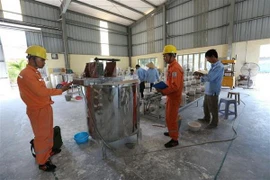 Công nhân Công ty Điện lực Hải Dương (Tổng Công ty Điện lực miền Bắc) khảo sát nhu cầu điện năng một cơ sở sản xuất gốm Chu Đậu. (Ảnh: Ngọc Hà/TTXVN)