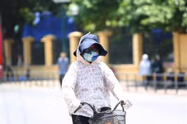 Người dân thủ đô chống chọi với nắng nóng bằng trang phục kín mít. (Ảnh: Thành Đạt/TTXVN)