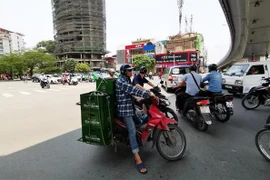 Tránh nắng dưới gầm cầu ảnh hưởng đến các phương tiện đang tham gia giao thông. (Ảnh: Thành Đạt/TTXVN)