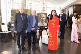 Hai họa sỹ người Canada vẽ tranh bác Hồ và tiến sỹ Nguyễn Đài Trang. (Ảnh Vũ Quang Thịnh/TTXVN)