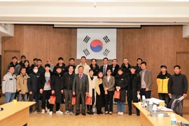 Đoàn công tác trao quà và chụp ảnh lưu niệm với lao động Việt Nam tại thành phố Ansan. (Ảnh: Đức Hưng/TTXVN)