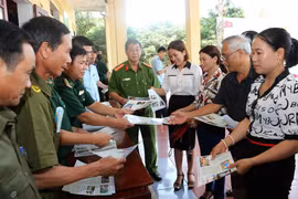 Lực lượng biên phòng, công an và tuyên truyền viên phát tờ rơi tuyên truyền về phòng, chống ma túy đến nhân dân địa bàn xã Sơn Kim 1, huyện Hương Sơn, tỉnh Hà Tĩnh. (Ảnh: Doãn Tấn/TTXVN)