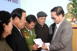 Ông Lê Xuân Tánh (phải) - Chủ tịch hội Chiến sỹ Thành cổ Quảng Trị - trao quà cho các hội viên. (Ảnh: Trịnh Bang Nhiệm/TTXVN)