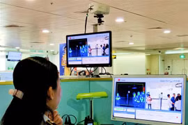 Nhân viên sân bay Tân Sơn Nhất kiểm tra màn hình hiển thị máy quét thân nhiệt đối với hành khách quốc tế đến Việt Nam. (Ảnh: Đinh Hằng/TTXVN)