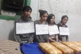 Các đối tượng bị bắt cùng tang vật . (Ảnh: TTXVN phát)