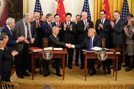 Tổng thống Mỹ Donald Trump (phải, phía trước) và Phó Thủ tướng Trung Quốc Lưu Hạc (trái, phía trước) tại lễ ký thỏa thuận thương mại giai đoạn một ở Washington DC. (Ảnh: THX/TTXVN)