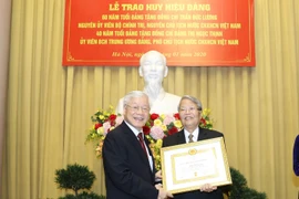 Tổng Bí thư, Chủ tịch nước Nguyễn Phú Trọng trao Huy hiệu 60 năm tuổi Đảng tặng nguyên Chủ tịch nước Trần Đức Lương. (Ảnh: Trí Dũng/TTXVN)